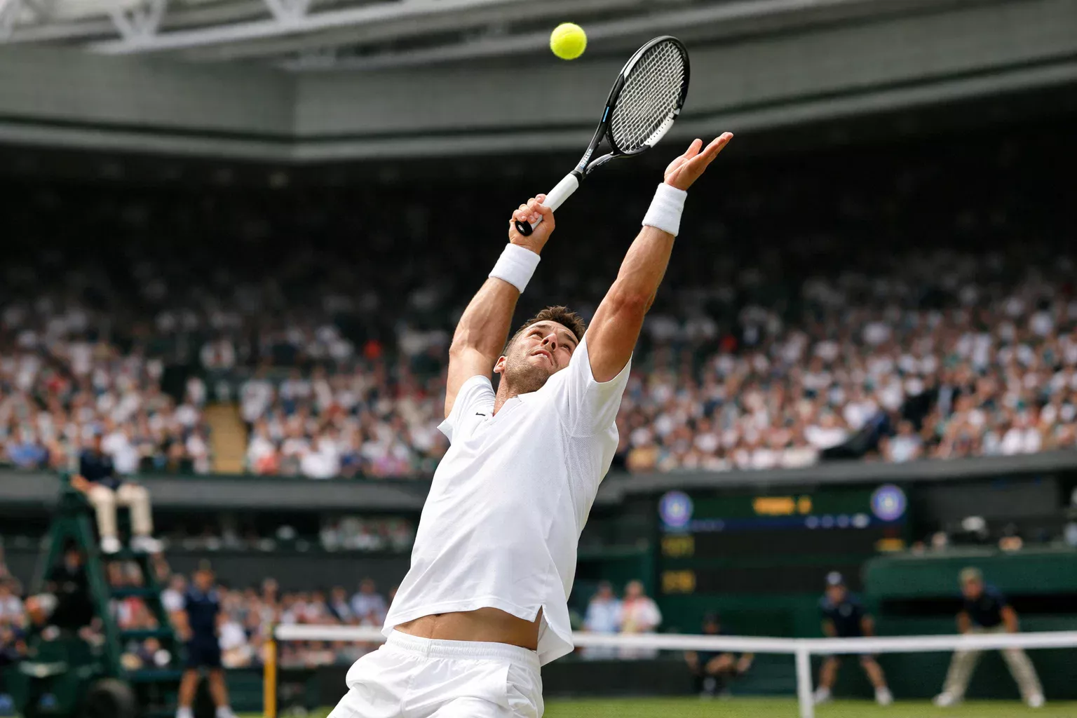 Tennisspieler serviert auf dem Rasenplatz in Wimbledon